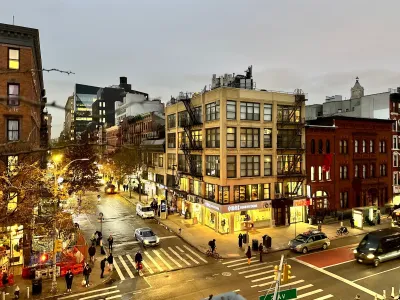 Looking down on street scene with people walking at dusk on vibrant East Village street, New York City.