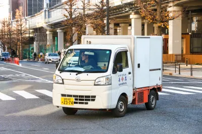 Small white kei truck on street in Tokyo, Japan.