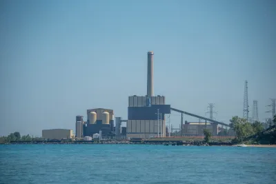 The J.H. Campbell Generating Plant, a concrete building in front of a large body of water.