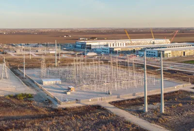 Aerial of large data center with power substation at golden hour.