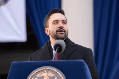 NYC Mayor Zohran Mandami speaks behind a blue podium.