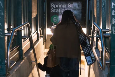 A woman descends into Spring Street station in NYC.