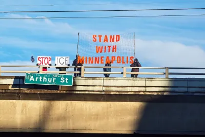  Protesters stand on top of a freeway overpass over the I-90 freeway with a Stand With Minneapolis banner as a result of the ICE shooting in Minnesota. 
