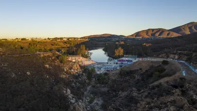 Drone photo of dam on upper Otay Lakes Reservoir. It is covered in graffiti. 