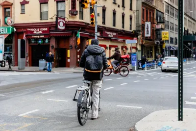 Man on e-bike in New York City on a cloudy day.