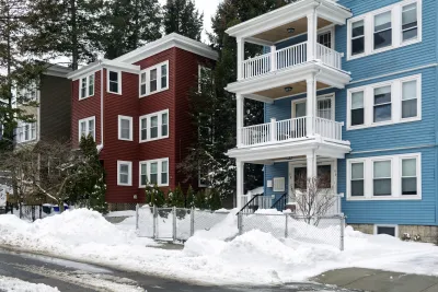 BLue and red triple-story homes in Boston, Massachusetts.