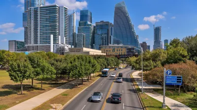A wide-angle overview of a busy street at Downtown Austin, with modern skyscrapers towering in background, on a bright sunny Autumn day.