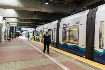 Security officer walks next to Sound Transit train in underground station in Seattle, Washington.