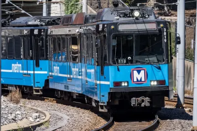 A blue Metrolink train with two cars drives toward the camera. 