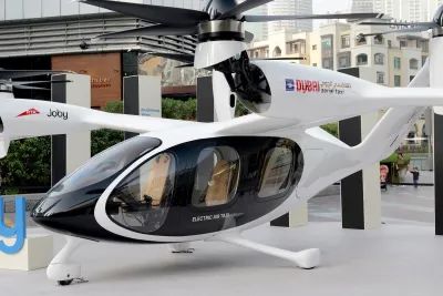 A white air taxi shaped like a helicopter on display in Dubai.