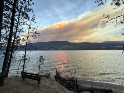 Wildfire smoke from the Kaiser Canyon and Modrite fires on the Colville Reservation drifts across the sky over Lake Roosevelt, casting an orange glow on the water as eastern Washington wildfires burn over 250,000 acres across the region