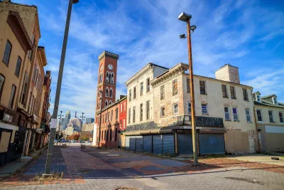 Historic abandoned brick buildings in Baltimore with boarded-up windows.