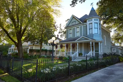 Light blue two-story Victorian home with corner turret in The Heights, Houston, Texas