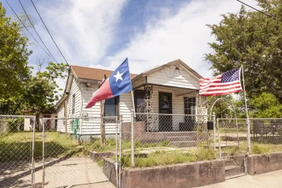 Small home with Texas and USA flags in front yard.