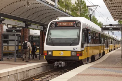 White Dallas light rail train at open-air platform.