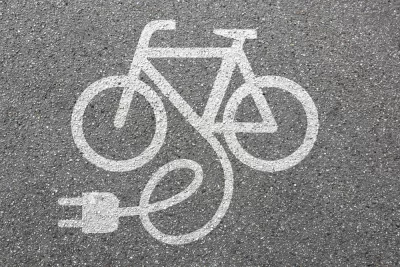 White electric bike logo on asphalt
