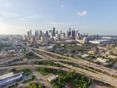 Aerial view of Houston freeway interchanges with downtown skyline in background