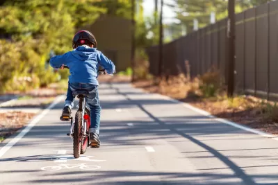 Small boy riding bike on two-way paved bike trail