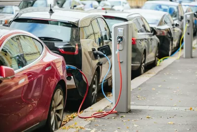Electric cars parked curbside and charging on a city street