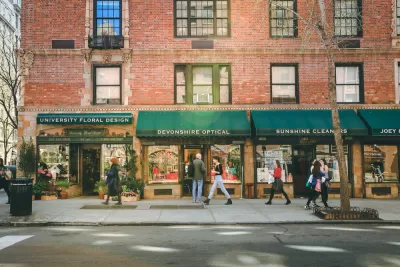 Greenwich Village street with red brick buildings with green awnings and businesses on first floor