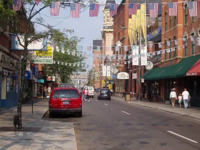Two-lane street in Detroit's Greektown with American and Greek flags strung across the street