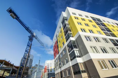 Multistory building under construction with crane visible on the left.