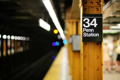 Close-up of yellow steel column on subway platform with sign: "34 Penn Station"