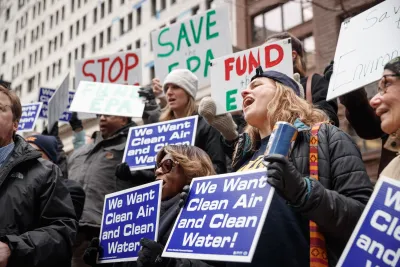 Protesters holding signs calling for clean air and water. 