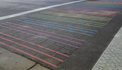 Rainbow striped crosswalk with thin stripes on asphalt in Sacramento, California
