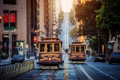 Historic cable cars on California Street in San Francisco, California with hill and city buildings in background