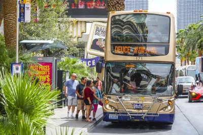 Gold double decker bus picking up passengers on the Las Vegas strip.