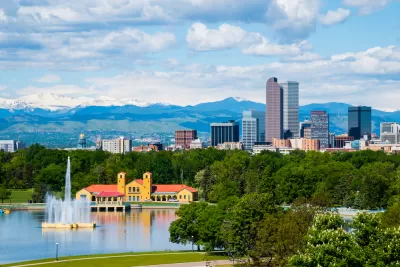Denver, Colorado skyline with park and lake in foreground and mountains in background