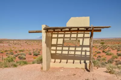 Adobe and wood bus stop shelter on deserted road in Navajo Nation
