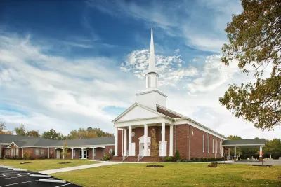 Traditional small brick church with tall white steeple in Virginia.