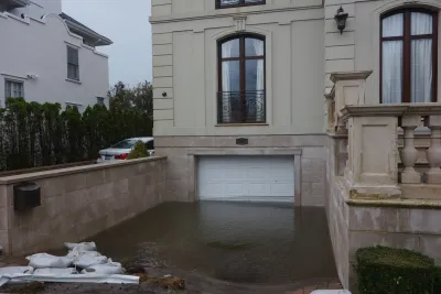 Basement-level garage door with floodwater halfway up on home in Far Rockaway, New York after hurricane.