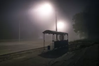 Bus shelter from behind at night with mist and streetlights