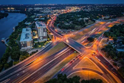Interstate 35 over Riverside Drive at dusk in Austin, Texas with downtown visible in background.