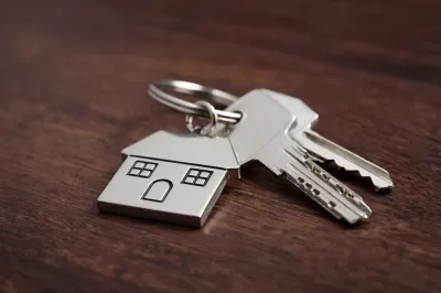House key with house-shaped keychain on table
