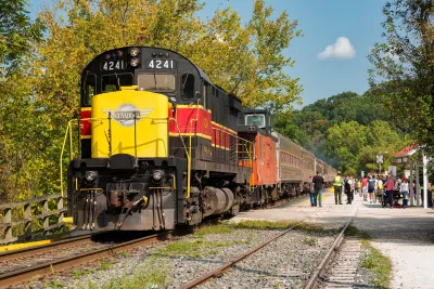Yellow, red, and black Cuyahoga Valley Scenic Railroad locomotive at station.