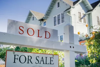 White house with For Sale and SOLD sign