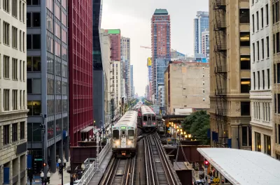 Two Chicago elevated trains with city buildings in background