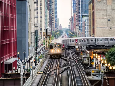 Chicago elevated train over busy city street surrounded by high-rise buildings