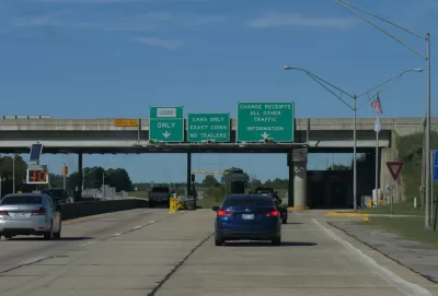 View of cars on Oklahoma road with green signs signaling tolls ahead