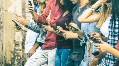 A row of young people outdoors using smartphones
