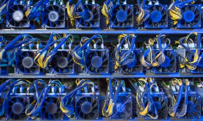 Wall of computer servers with blue and yellow cables for cryptocurrency mining