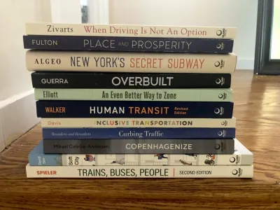 Stack pf urban planning books on table.
