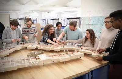 Students interacting in a group with a wooden diorama