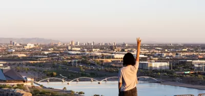 Arizona State University Master of Urban and Environmental Planning primary imager with a somen pointing to the sky and you see the city and river in the distance.