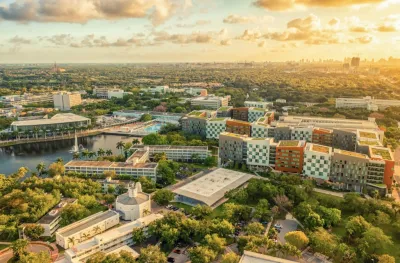 Image bird eye view of Miami with lots of greenery and modern buildings nearby a small body of water with a pier deck