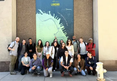 Group of students standing in front of a tall map of a San Francisco pier